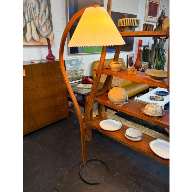 The iconic Caprani lamp that holds space elegantly with its bent frame, pleated shade, and horseshoe iron base. A classic...