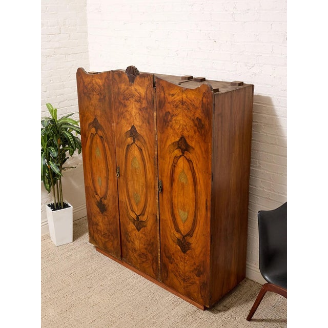A truly unusual vintage Art Deco wardrobe combining richly figured burl wood with dramatic hand-painted botanical motifs...