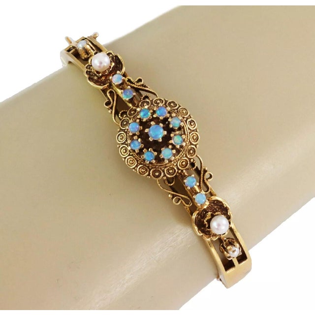 This lovely vintage bracelet is crafted from 14k yellow gold, the front half has a floral center part decorated with small...