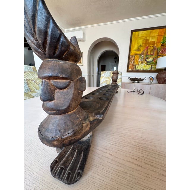 This item is a vintage, hand-carved wooden Mancala game board. This board features ornate figural carvings at the ends...