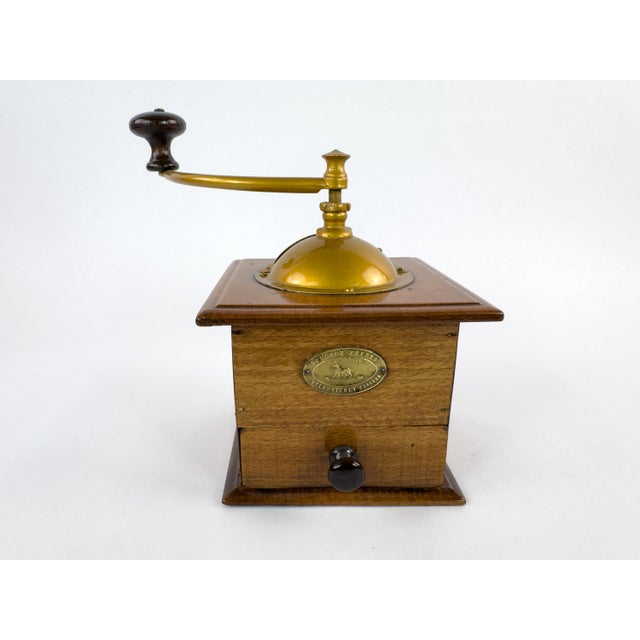 An attractive early 20th-century French manual coffee grinder by Peugeot Frères, featuring a traditional wooden body, a...