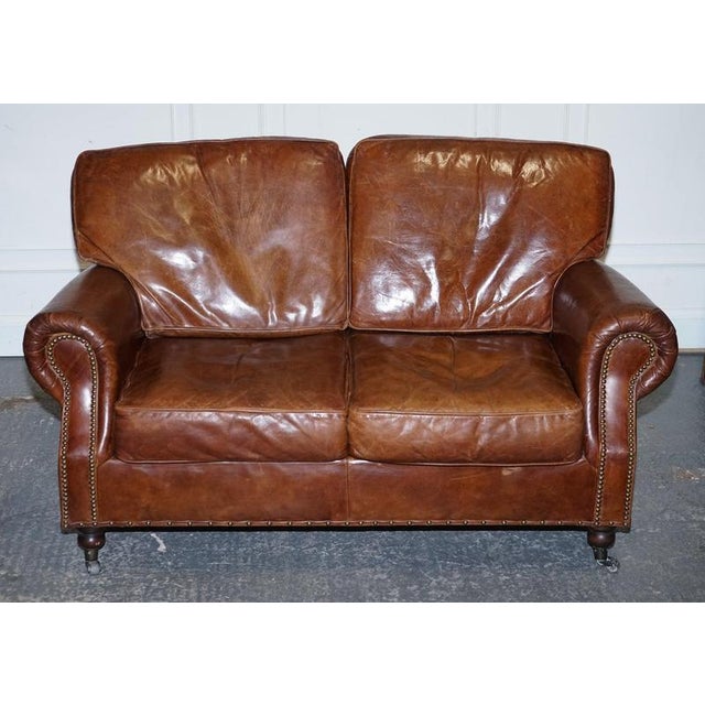 A handsome Halo / Timothy Oulton style Balmoral two seater sofa, upholstered in rich brown heritage leather with a...
