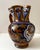 A richly decorated Italian majolica pitcher featuring a dramatic griffin or dragon motif rendered in deep cobalt blue,...