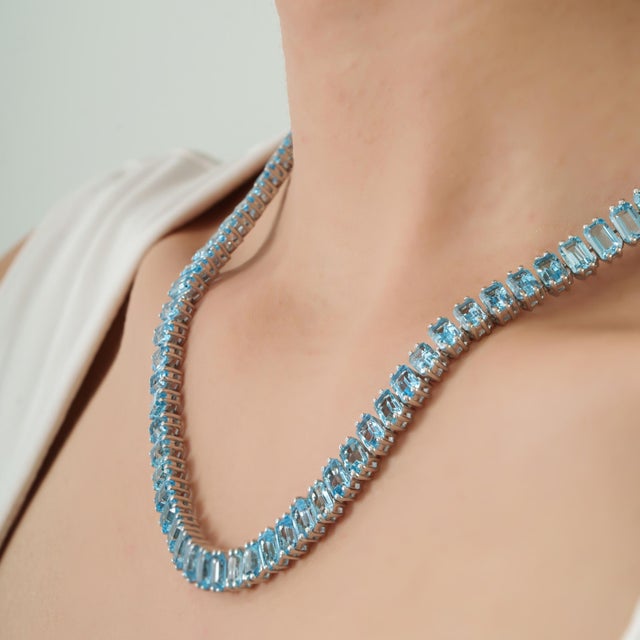 This timeless sky blue topaz jewelry set is crafted in 925 sterling silver and includes a tennis-style necklace paired...
