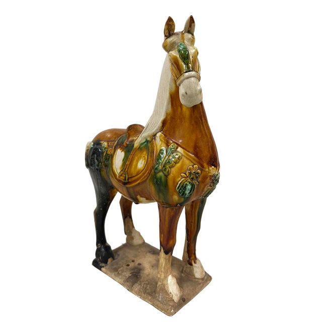 A large vintage Tang style Sancai glazed terracotta horse. This exquisite piece features a striking green and brown color...