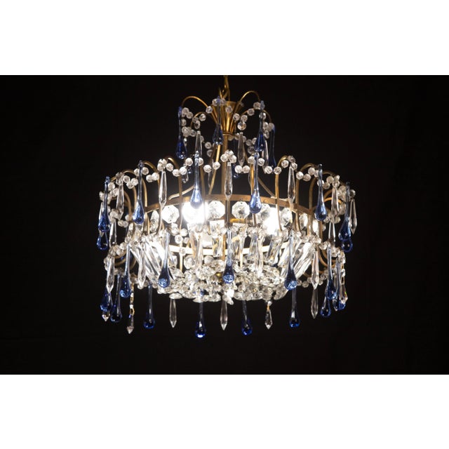 Emperor-style chandelier formed by rounds of crystals decorated with blue glass drops. The chandelier is 100 centimeters...