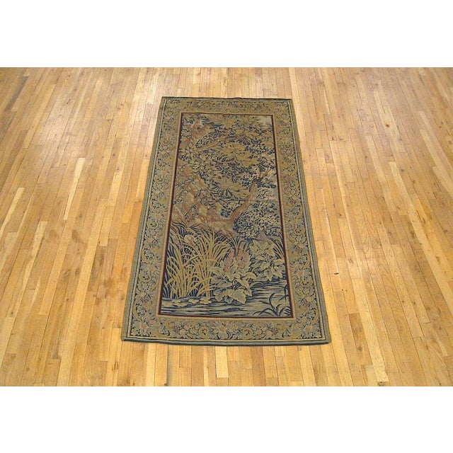 A loomed French landscape tapestry from the first quarter of the 20th century, circa 1920, picturing a wooded area by the...