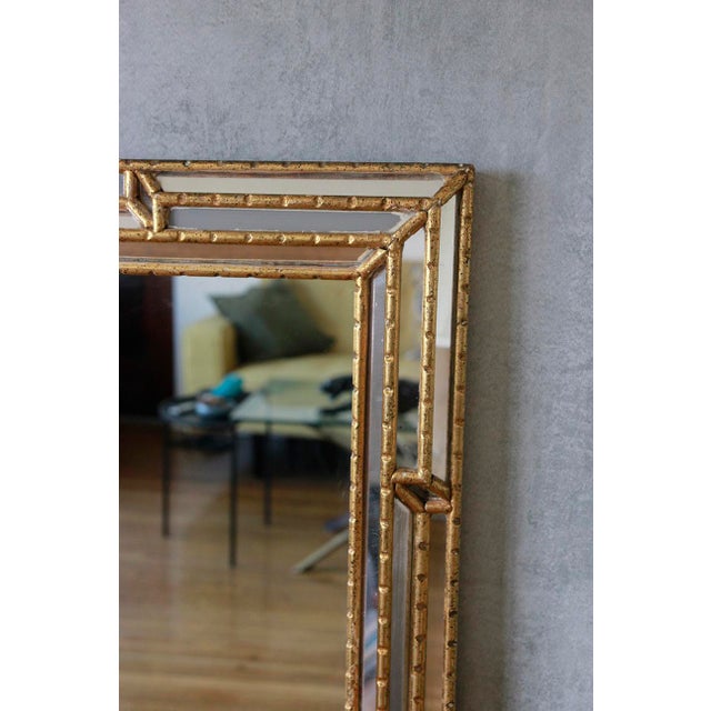 Vintage Hollywood Regency mirror from the 1950s, adorned with gilt detailing. This large wall piece features a central...