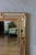 Vintage Hollywood Regency mirror from the 1950s, adorned with gilt detailing. This large wall piece features a central...