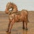 A small Indian vintage carved and rust colored wooden horse sculpture from Madras with distressed patina. Born in the...