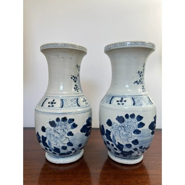 This is a beautiful pair of chinoiserie blue and white vases with Greek Key motif around the top edges as well as cherry...