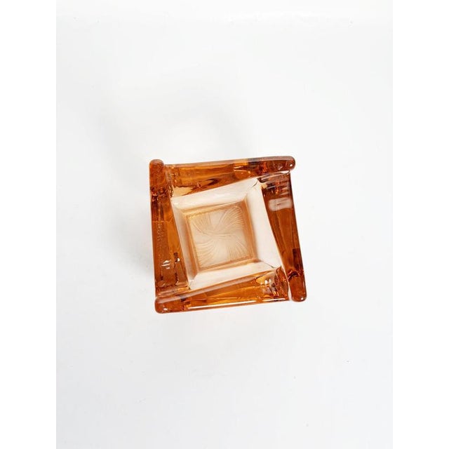 Vintage French ashtray dating from the 1960s, crafted from thick molded glass in a warm red-orange tone. Its compact...