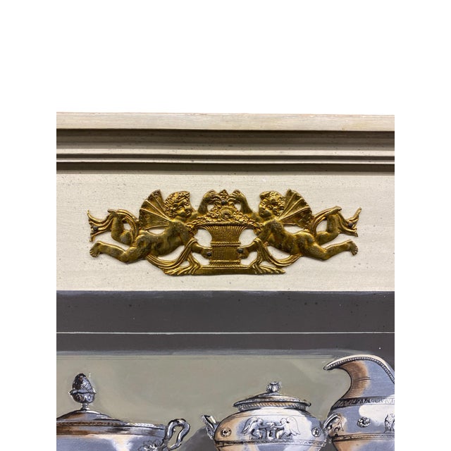 A beautiful Italian trompe l’oeil hand-painted wood panel depicting a neoclassical open cabinet filled with finely...