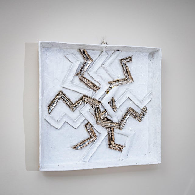 Pair of square wall objects made of white-glazed and enameled ceramic, featuring deeply recessed frames. The central...