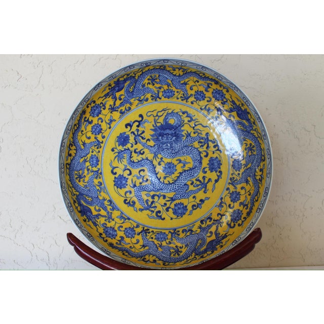 Striking 20th century Chinese porcelain charger featuring an intricate cobalt blue dragon motif set against a vibrant...