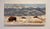 This oil painting captures a serene winter landscape, featuring a few bison grazing on a snow-covered field against a...