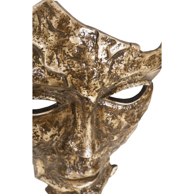 With its fragmented, gold-brushed surface and hollow eyes, the Mask Sculpture exudes a powerful presence. Raw and...