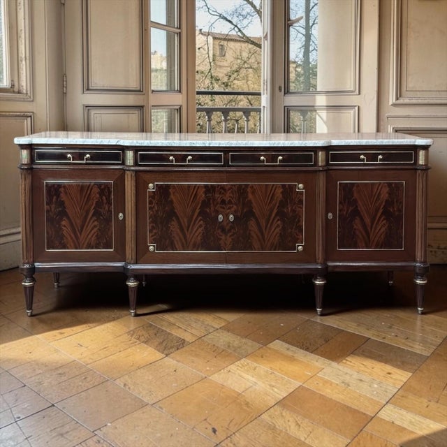 Antique Directoire Style French Mahogany Buffet with Carrara Marble Top is a striking and elegantly proportioned piece,...