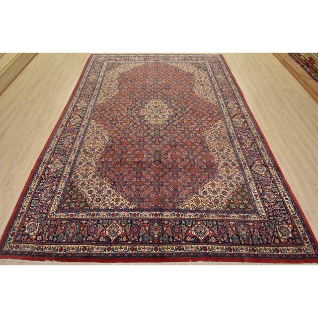 An authentic vintage traditional Sarouk rug hand-knotted with fine wool and natural dyes. This intricately woven rug...