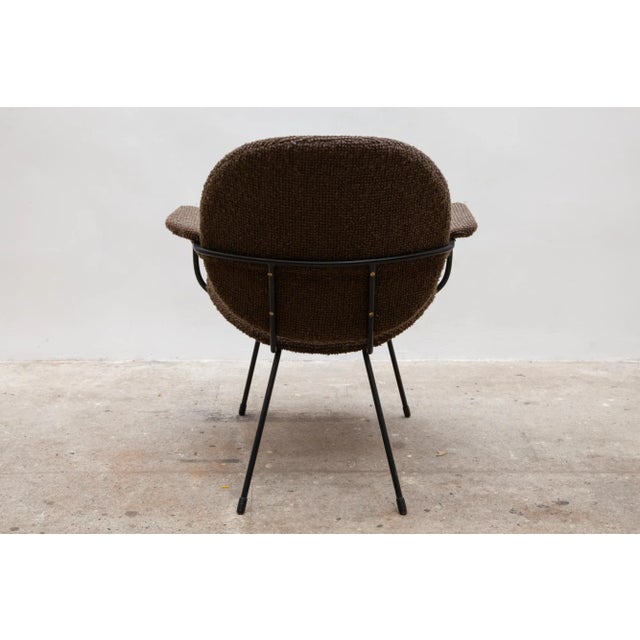 This is a vintage chair with a mid-century style black metal frame. It features textured upholstery in a rich charcoal brown.