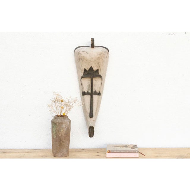 An authentic Fang Ngil mask, standing at an impressive 33 inches high and approximately 12 inches wide. Originating from...