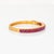 Stylish vintage ruby bangle bracelet crafted in 18 karat yellow gold. Oval faceted rubies measure approx. 5mm x 4.5mm...