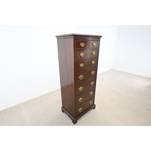A beautifully crafted Drexel Heritage Georgian-style tall chest finished in rich mahogany with classic bracket feet and...