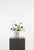 A fresh, textural mix of blue cornflower, cream poppy, and soft green snowball. The contrast between crisp whites and...