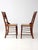 A late 19th century pair of American Eastlake side chairs with turned spindle backs and woven cane seats. The vertical...