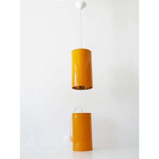 - Pair of pendant lamps - Made by Erco in Germany - From the 1970s - Executed in orange-lacquered aluminum & metal - Each...