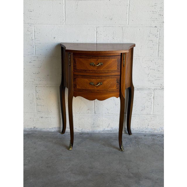 This compact rosewood and teak entry table features a curved front, two drawers, and a shaped top. Slender cabriole legs...