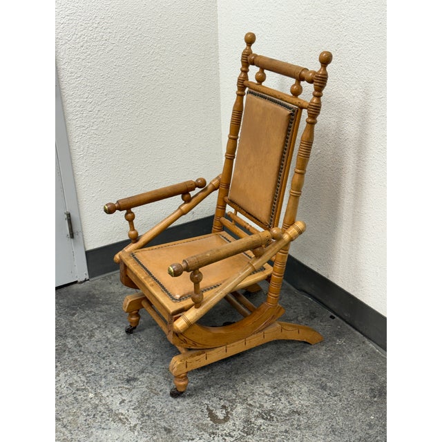 Design Plus Gallery presents an Antique Victorian Rocker. The rocker features a turned spindle frame and traditional...