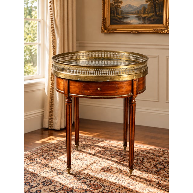 A handsome French Louis XVI–style bouillotte table in mahogany dating to the 19th century, retaining its original grey...
