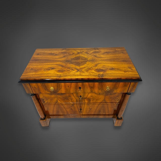 A Biedermeier writing desk with an architectural design, circa 1820. The body is flanked by two freestanding walnut...