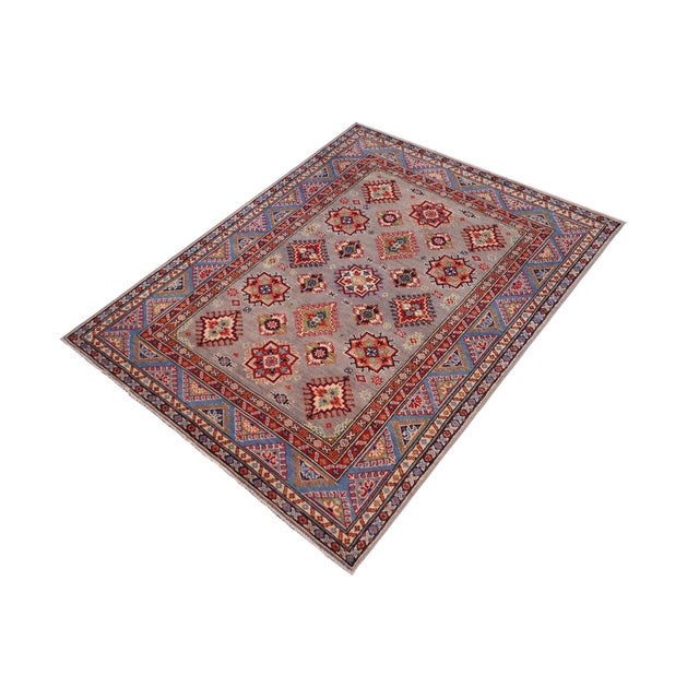 Enhance your home with this exquisite hand-knotted Kazak rug, crafted from fine hand-spun wool and dyed with all-natural...