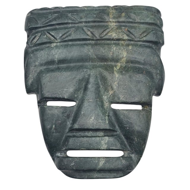 This pair of green stone mask plaques is executed in the Pre-Columbian revival tradition, drawing directly from Olmec and...
