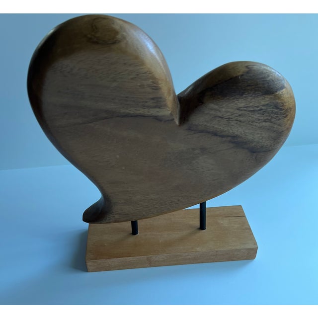 Vintage wood heart sculpture on a wood stand, held in place by two metal black rods. A beautiful, natural piece to add to...