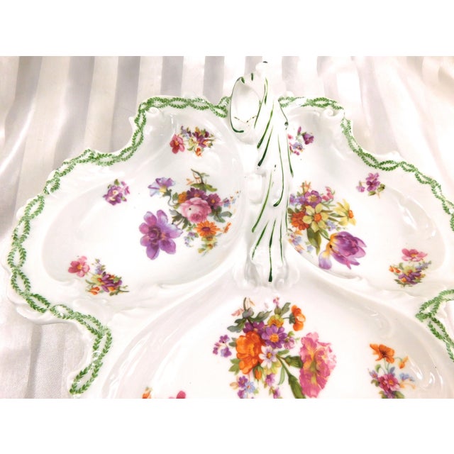 This is a white unmarked three section serving tray with handle. It has a multicolor floral design in each section and a...