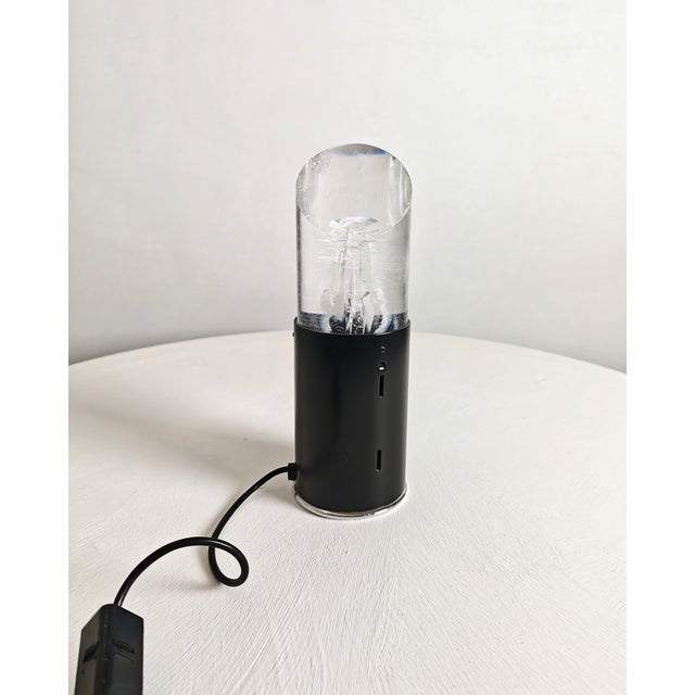 Rare table lamp with a chromed steel base. Cylindrical black enameled steel support with a thick acrylic glass diffuser....