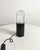 Rare table lamp with a chromed steel base. Cylindrical black enameled steel support with a thick acrylic glass diffuser....