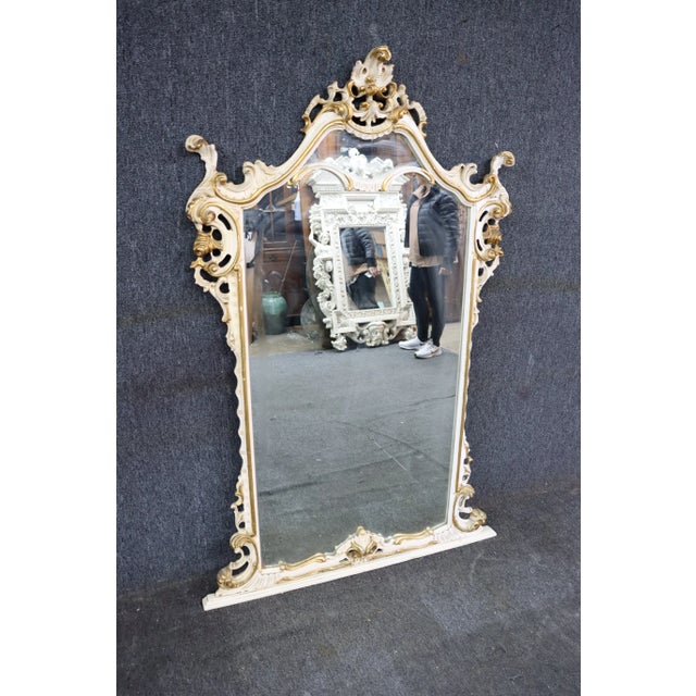 Over the mantel Italian style ornate mirror in cream with gold gilded accents.