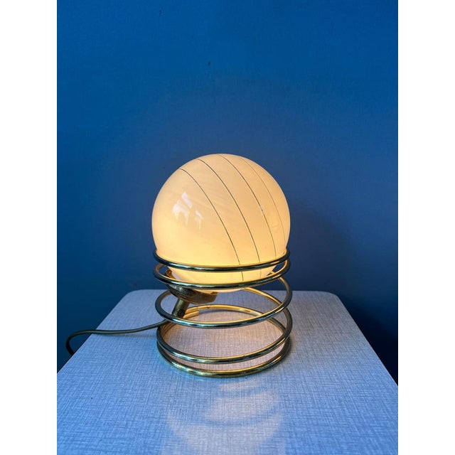 Set (2) of mid century hollywood regency eyeball table lamps with golden spiral base and opaline glass shade. The shades...
