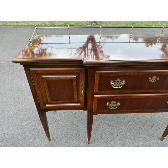 Timeless Federal-style mahogany sideboard featuring beautiful inlaid details, original brass gallery rail, brass hardware,...