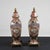 Pair of chinese ceramic potiche vases with worked metal base, richly decorated with oriental graphics in bright blue,...