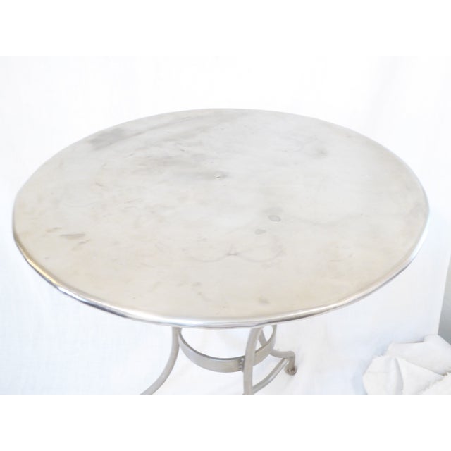 This polished steel cafe table is 27.25"H x 22"Diameter.