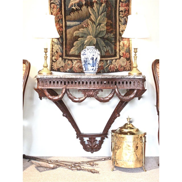 A fine serpentine carved oak wall mounted console, ca. 1780, with an open frieze, and a boldly carved pendant laurel swag...