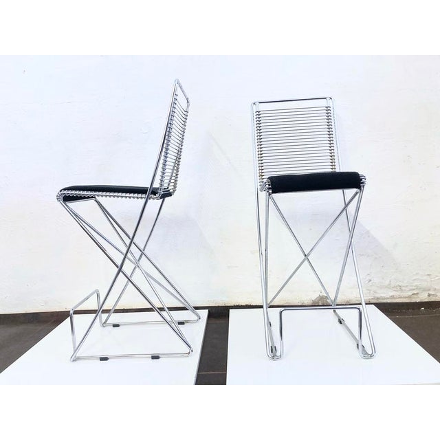 Two bar stools from the 1980s, designed by Till Behrens for Schlubach. Chrome-plated metal, fabric-covered seat cushion...