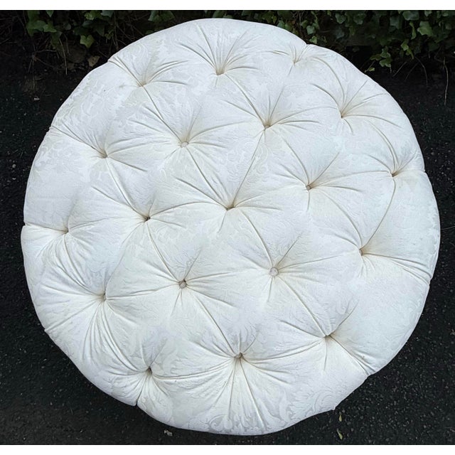 Stately custom upholstered ottoman on casters. Tufted with beautiful contrast fringe and tassel detail. Fabric is odor...