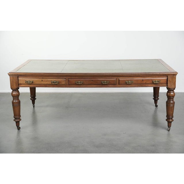 This beautiful original antique English writing desk/partner desk on wheels has 6 drawers and a green leather top. It...