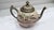Elegant vintage decorative teapot featuring a hand-painted cattail and marsh scene on a soft blush-colored porcelain body...